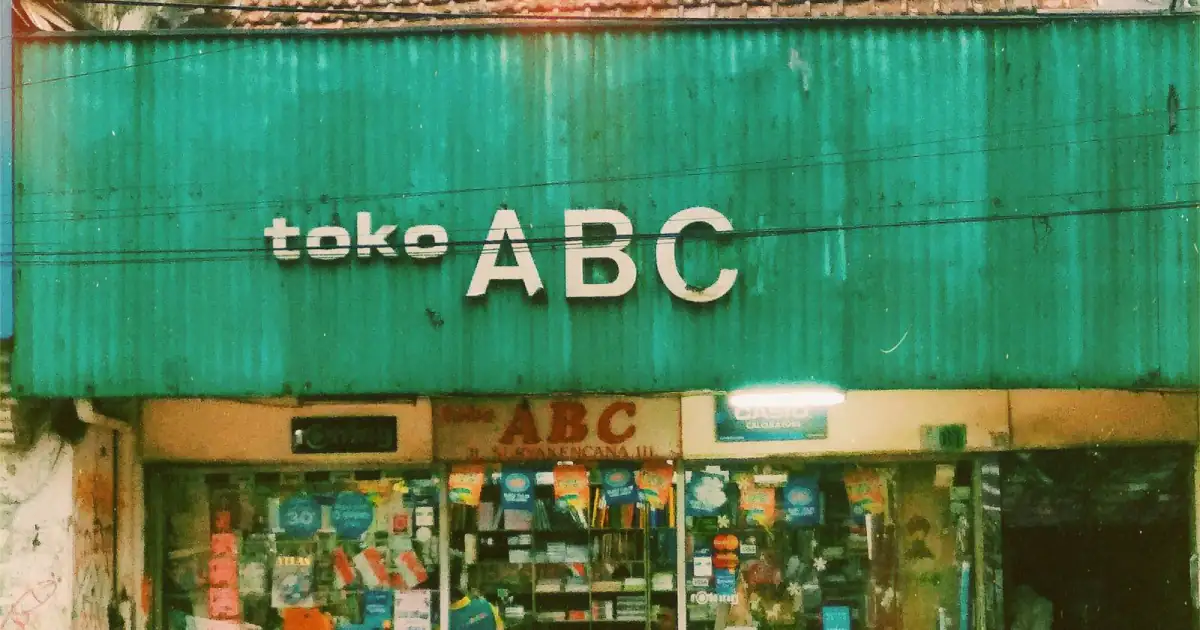 Papan nama besar bertuliskan toko ABC di atas sebuah toko alat tulis